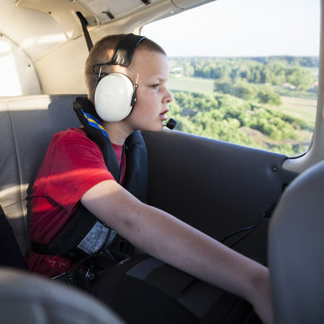 Boy looking through window of private plane
