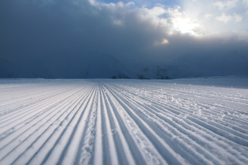 Fototapeta na wymiar processed snowcat track stripes on snow
