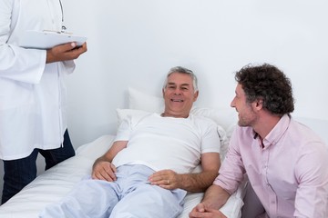 Obraz na płótnie Canvas Man sitting next to patient