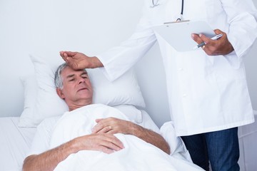 Male doctor examining senior man