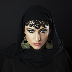 Beautiful Caucasian young woman with black fancy Arabian costume