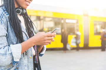 Black young woman typing on smart phone in Berlin © william87