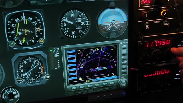 Flight control panel showing altitude and speed details, pilot switching radio