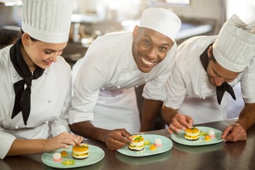 Chefs team finishing dessert plates