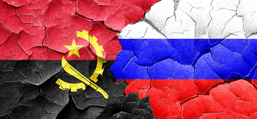 Angola flag with Russia flag on a grunge cracked wall