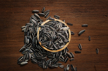 sunflowers seeds in wood bowls on wood background
