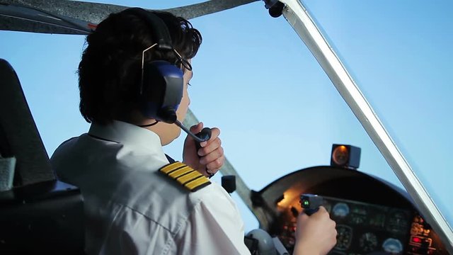Male pilot talking to air traffic controller using radio communication system