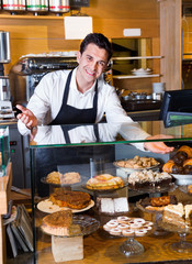 Fototapeta na wymiar Friendly positive smiling cafe staff offering fancy