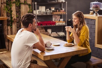 Two smiling hipsters drinking coffee 