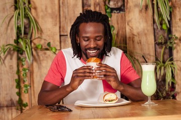 Facing view of hipster man eating sandwich
