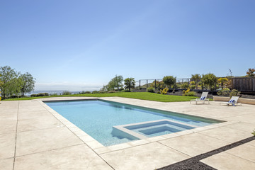 Luxury swimming pool and blue water with lounging chairs. 