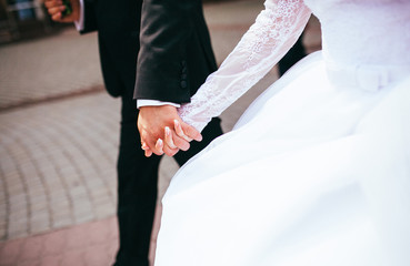 Bride and groom holding hands outdoors