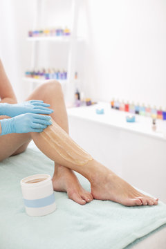 Mid adult woman receiving a sugaring treatment