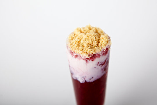 Cocktail with ice-cream, raspberry and cookie crumbs on the white background