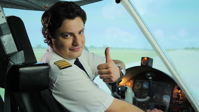 Happy pilot smiling at camera, thumbs up sign, successful career in aviation