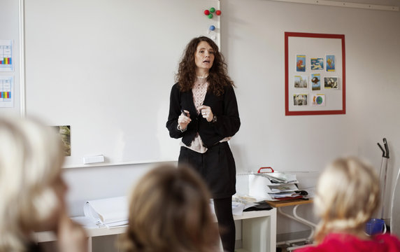 Female teacher teaching children in classroom
