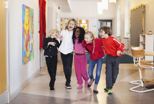 Happy children walking in school corridor
