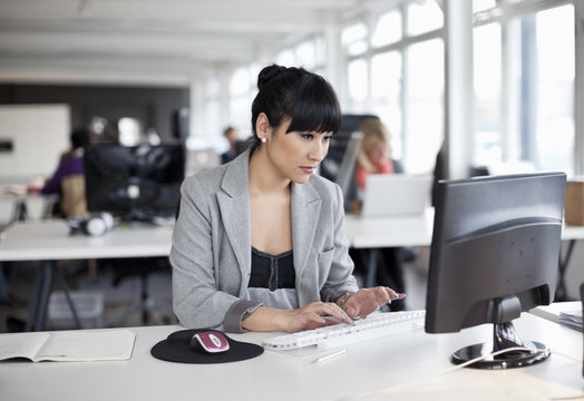 Businesswoman sitting at desk typing