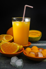 Glass with fresh ice cold pressed melon-orange juice and fresh f