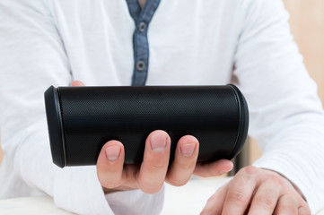 Man shows Modern wireless audio device.