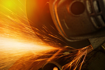 Sparks from cutting metal abrasive disk of angle grinder