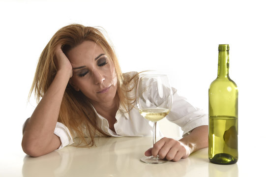 blond wasted and depressed alcoholic drunk woman drinking white wine glass desperate sad