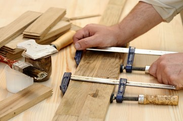 Carpenter hands at work with clamps