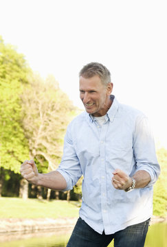 Happy man standing by pond