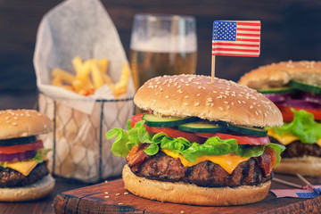 American Burger with bacon,cheese,tomato,lettuce and french fries at a Picnic for 4th of July