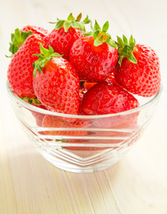 Strawberries in a glass piala on a white wooden table