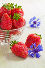 Strawberries in a glass piala on a white wooden table