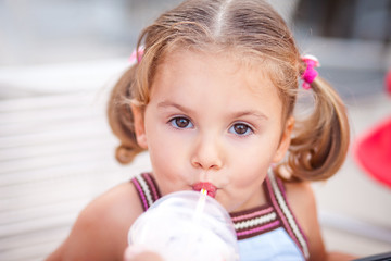 portrait of a little girl who drinks milk or milkshake