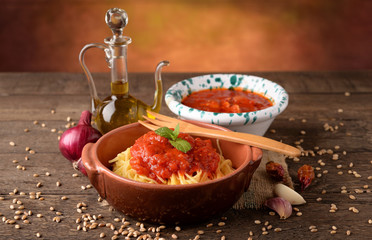 Bowl of pasta all 'egg and bowl with tomato sauce and oil cruet
