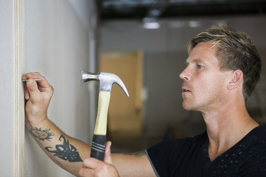 Carpenter hitting a nail with a hammer