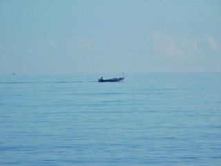 A boat sailing in the blu sea near the sky