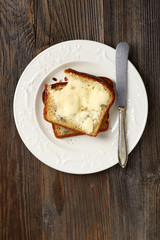 Sliced bread with butter on wooden table
