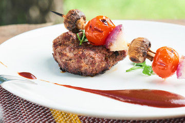 Healthy dinner of steak and vegetable skewers served on a white plate
