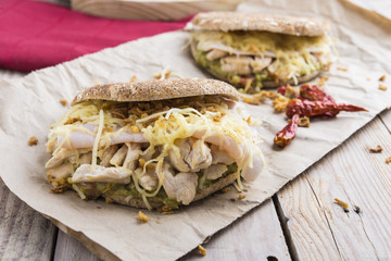 Sandwich with chickend and guacamole, cheese.