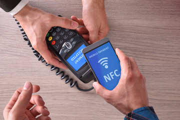 Customer paying a merchant with nfc top view