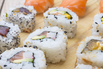 Different Sushi rolls,wasabi and ginger on a plate on wooden bac