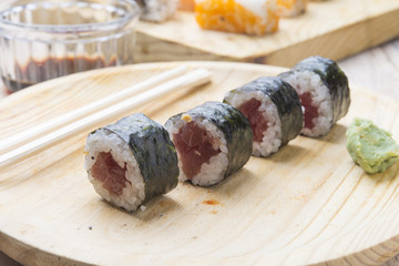 Different Sushi rolls,wasabi and ginger on a plate on wooden bac