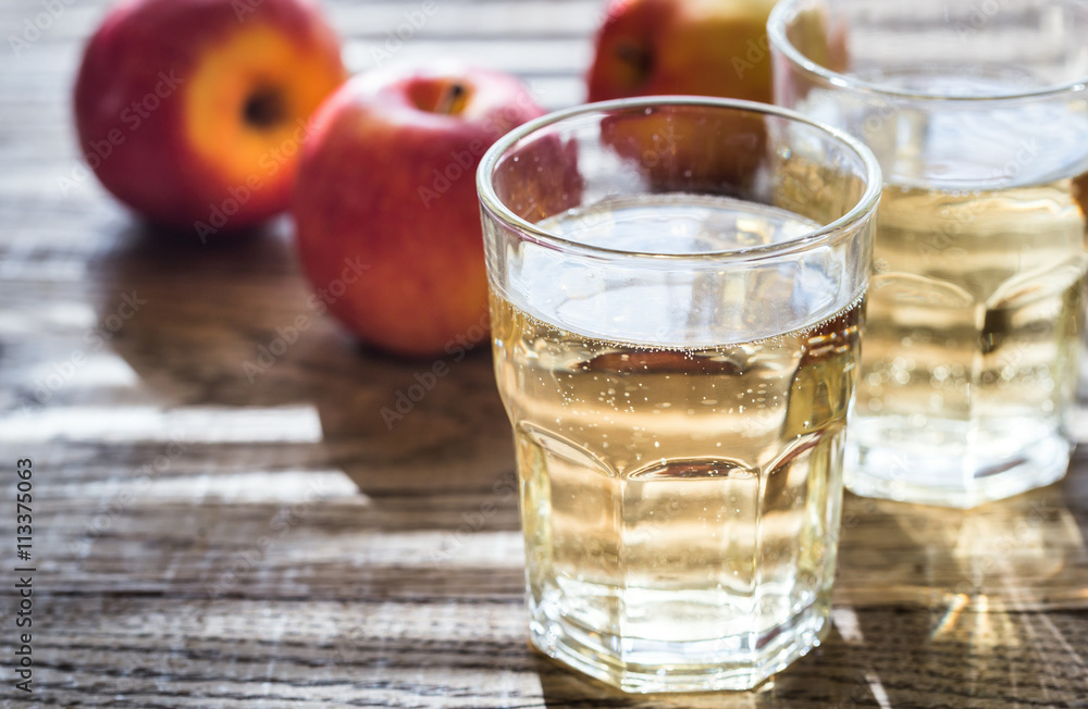 Wall mural two glasses of cider on the wooden background