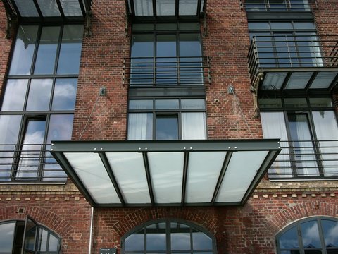 Modernes Vordach aus Stahltr&auml;gern und Milchglas am alten Speicher aus rotbraunem Backstein im Hafenviertel oder Hansaviertel am Hafen am Dortmund-Ems-Kanal in M&uuml;nster in Westfalen im M&uuml;nsterland