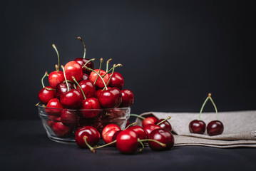 ripe juicy cherries in a glass on a dark background