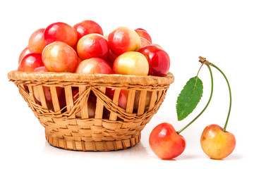 yellow cherries in a wicker basket isolated on white background