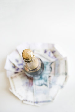 Money under bottle of champagne