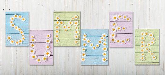 Word SUMMER from flowers on wooden background