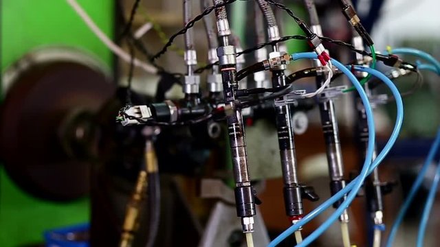 Testing diesel injector in his workshop.