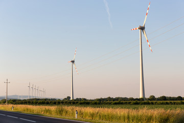 Beautiful fields surrounding windmills on the field during summer day with blue sky