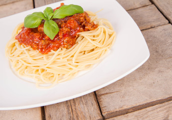 Spaghetti bolognese on a plate on a wooden background